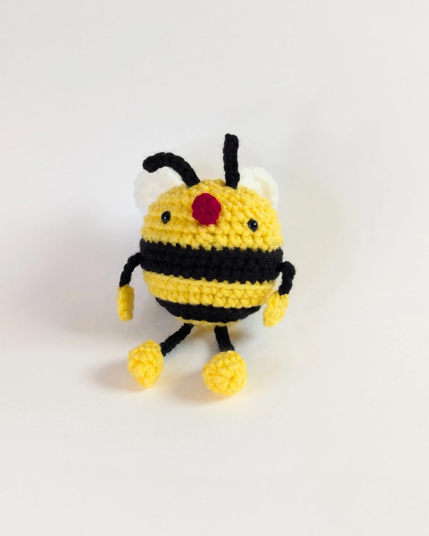 A crocheted soft toy shaped like a bumble bee