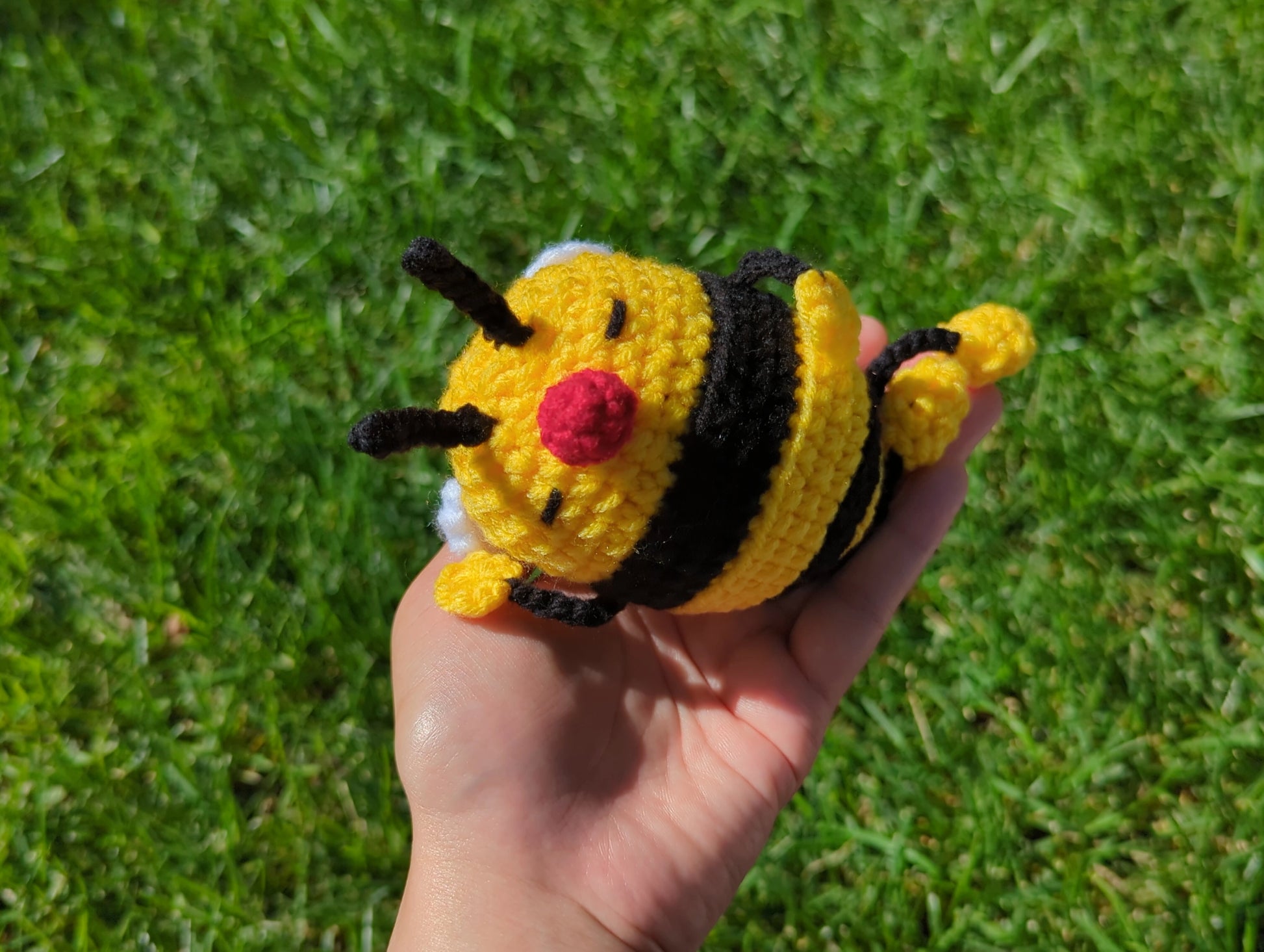 crocheted soft toy of a cartoon bumble bee taking a nap