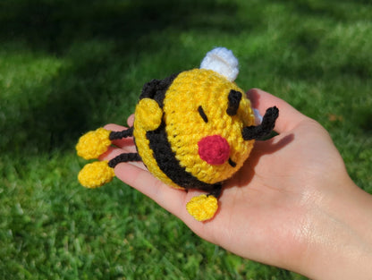 crocheted soft toy of a cartoon bumble bee taking a nap