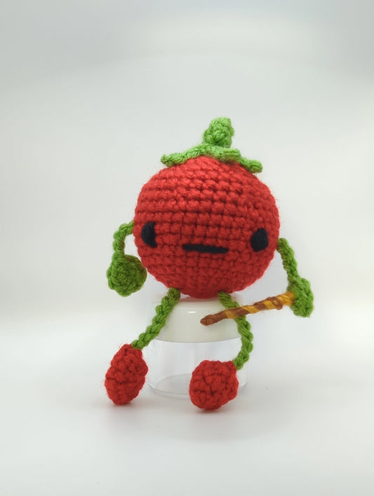 crocheted soft toy of a cartoon tomato holding a wand