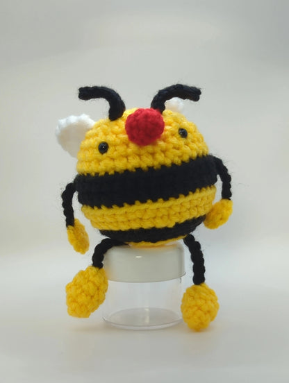 Crocheted soft toy of a cartoon bumble bee against a white backdrop