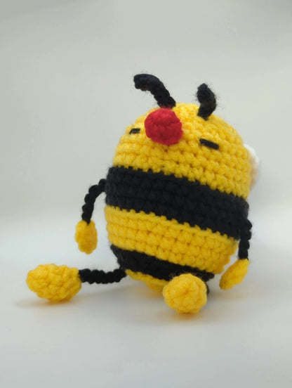 crocheted soft toy of a cartoon bumble bee taking a nap