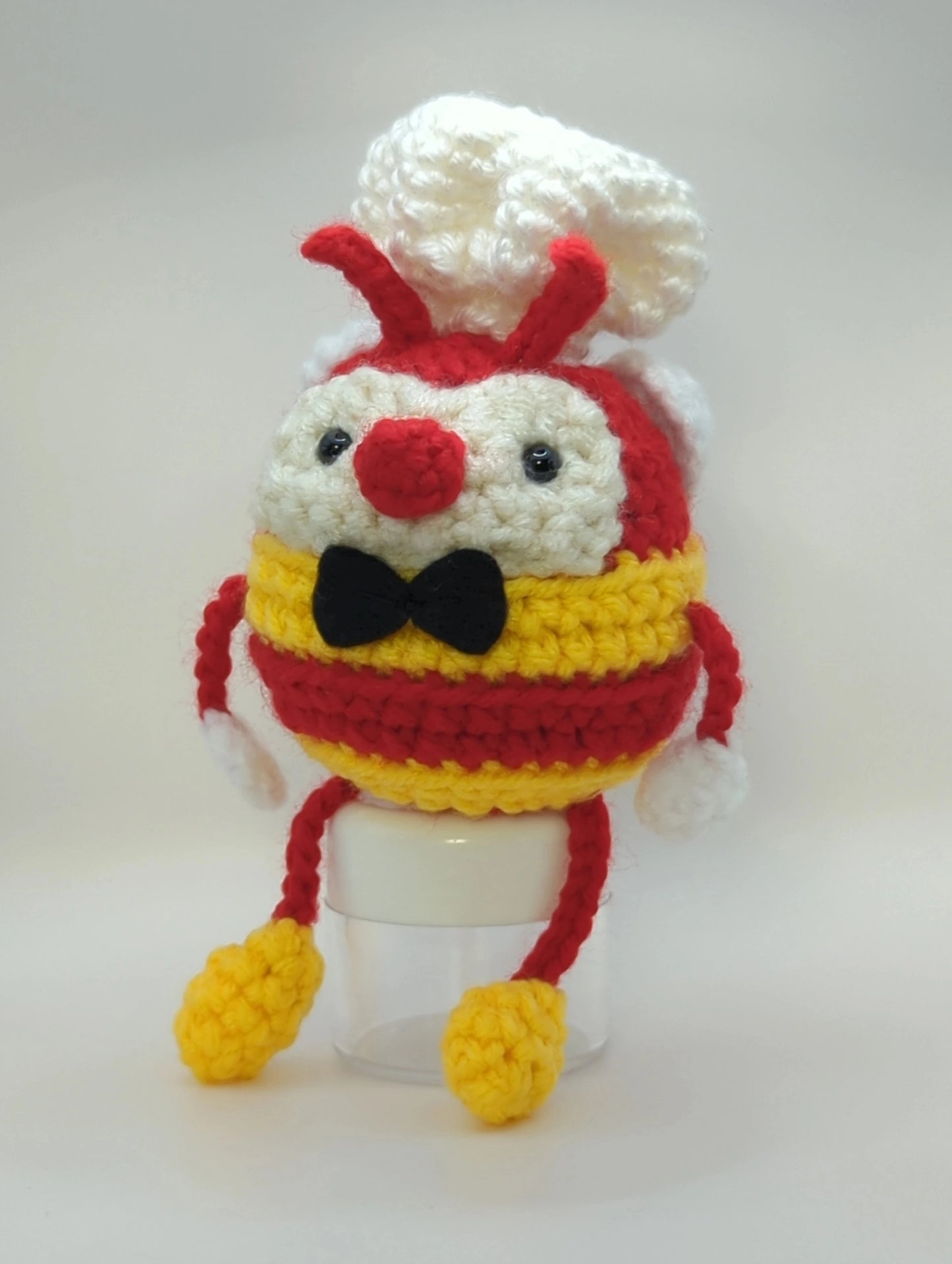 Crocheted soft toy of a cartoon bumblebee, dressed like the mascot of Filipino food chain, Jollibee.