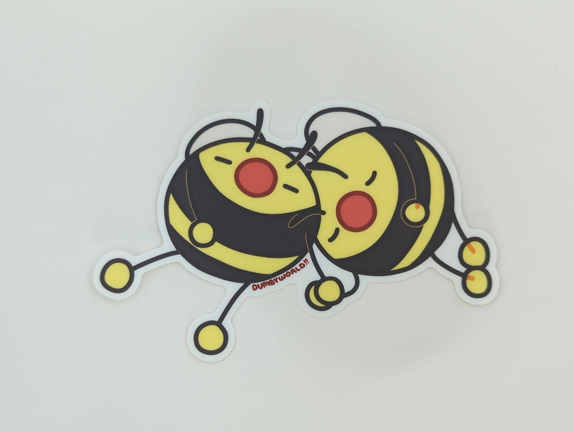 a sticker of two cartoon bumble bees taking a nap together